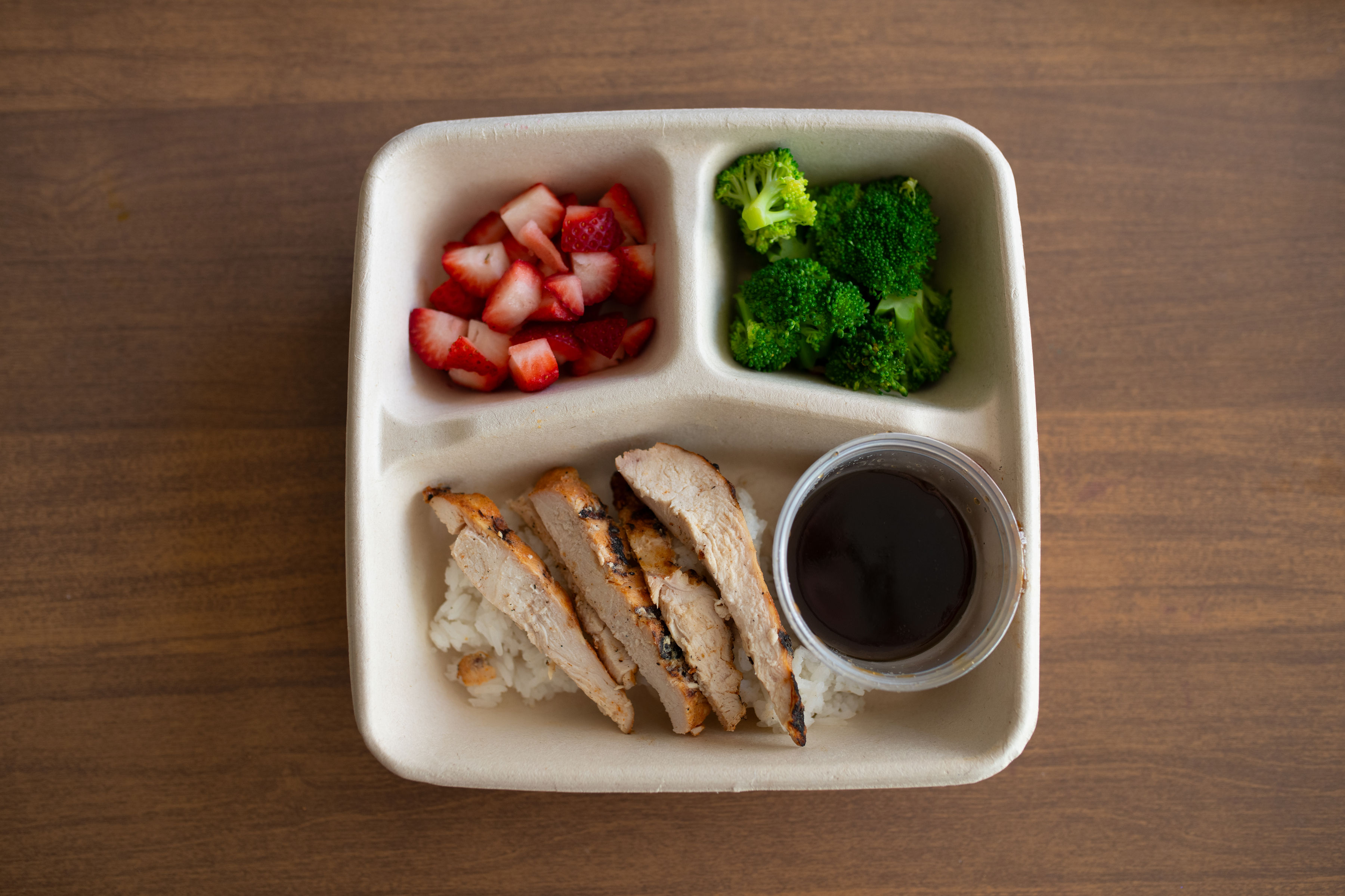 Happy Tummy Teriyaki kids meal with teriyaki chicken over rice, steamed broccoli and carrots, and fresh berries